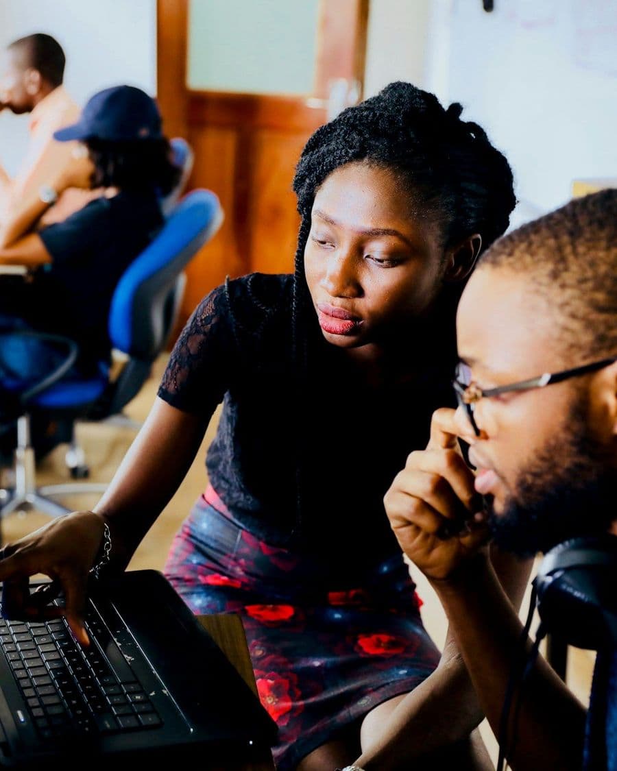 Two professionals pair-working at a laptop, focused on the screen together