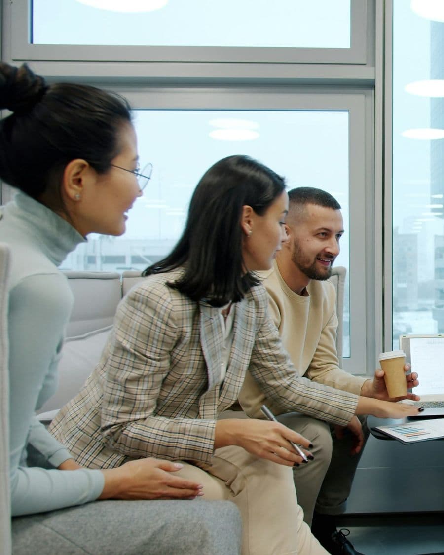 Diverse business team in a strategic discussion in a bright glass-walled office lounge