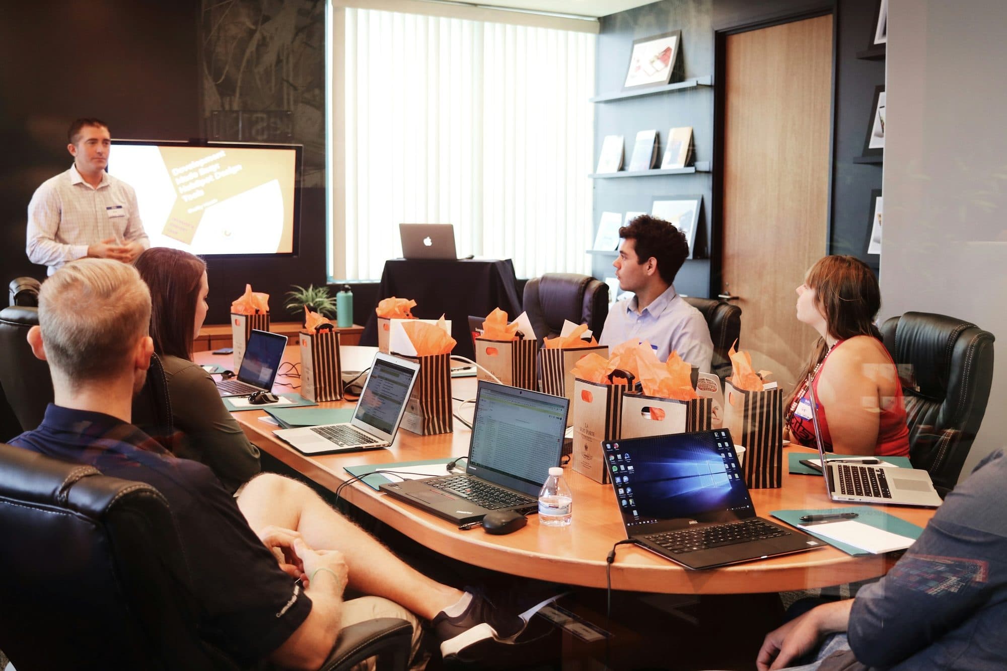 A facilitator leads a hands-on workshop as participants work on laptops